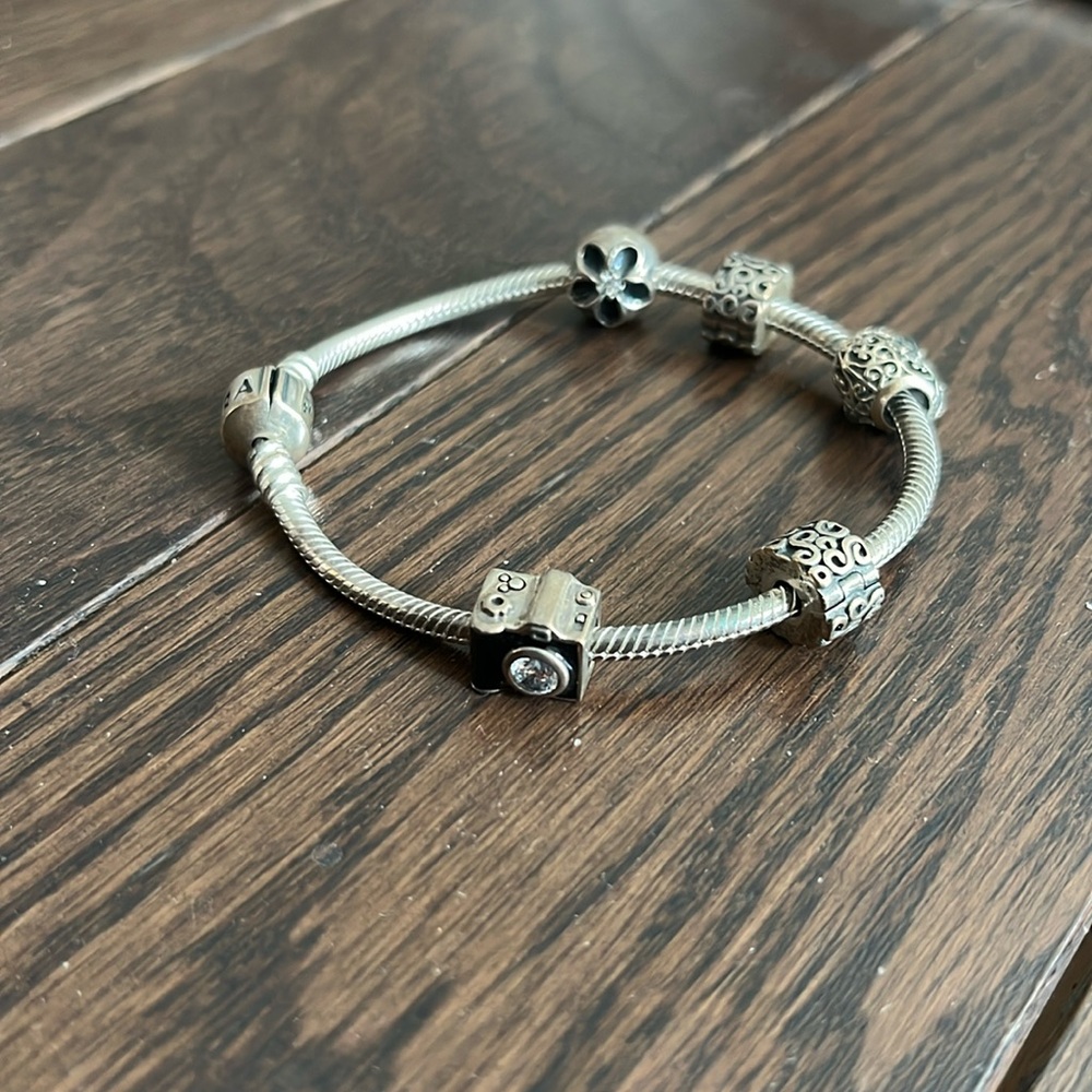 Pandora charm bracelet with three charms.